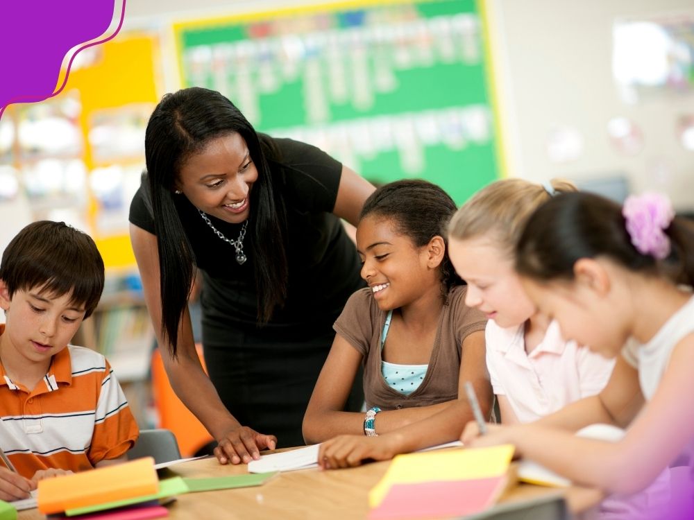 Agrupamento de alunos e professora realizando intervenções, para ilustrar uma estratégia essencial para o plano de ação para alunos com dificuldade em matemática.