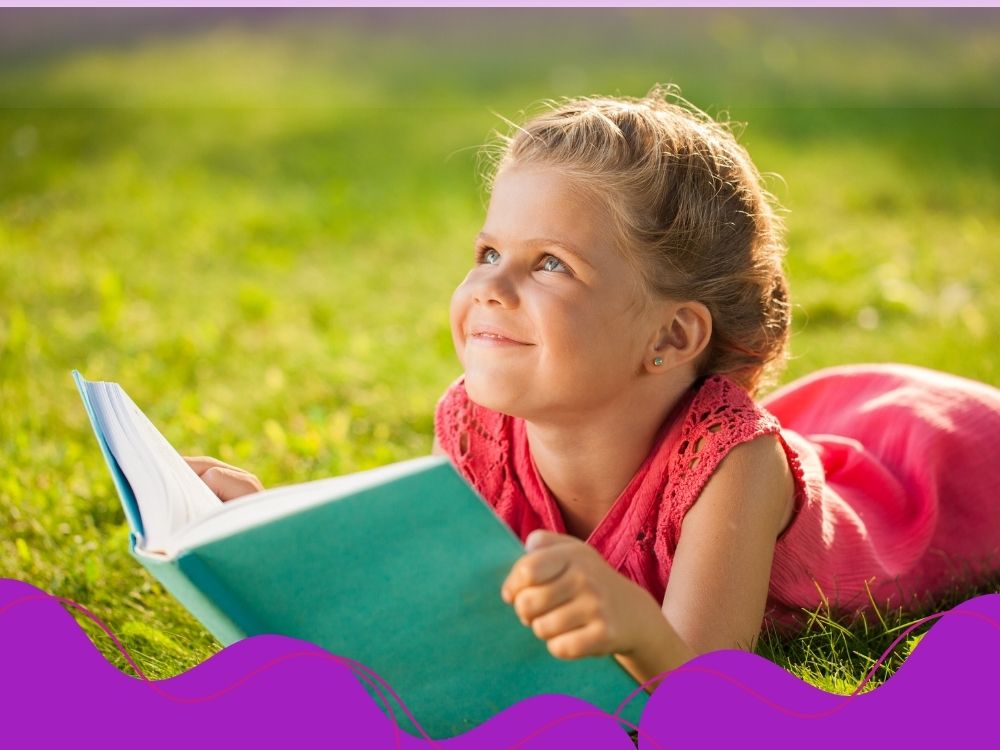 Criança feliz com um livro nas mãos.