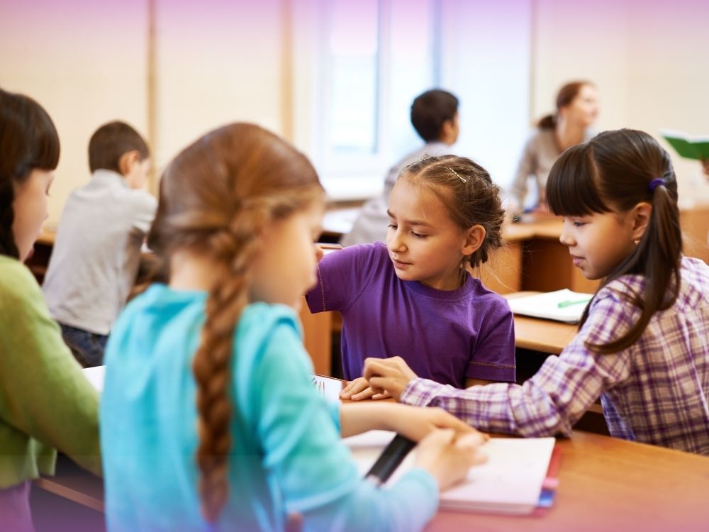 Alunos interagindo em grupo para ilustrar a importância da interação para a aprendizagem, como é comprovado pela neurociência.