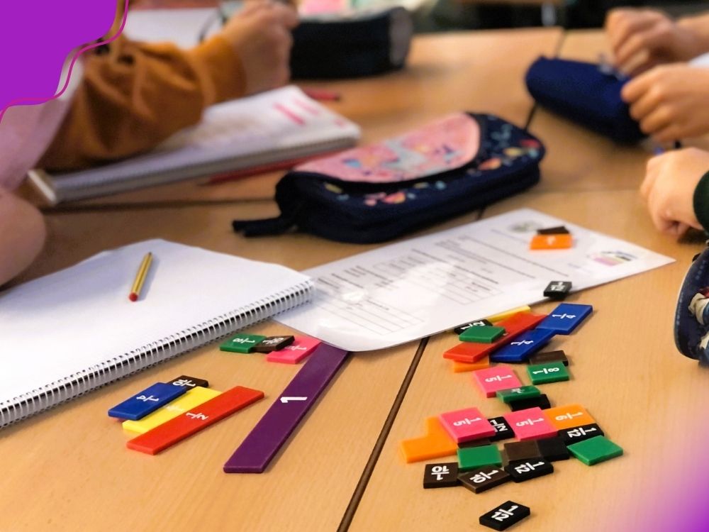 Grupo de alunos realizando atividades com recursos manipuláveis de frações, para ilustrar atividades diferenciadas propostas no plano de ação para alunos com dificuldade em matemática.